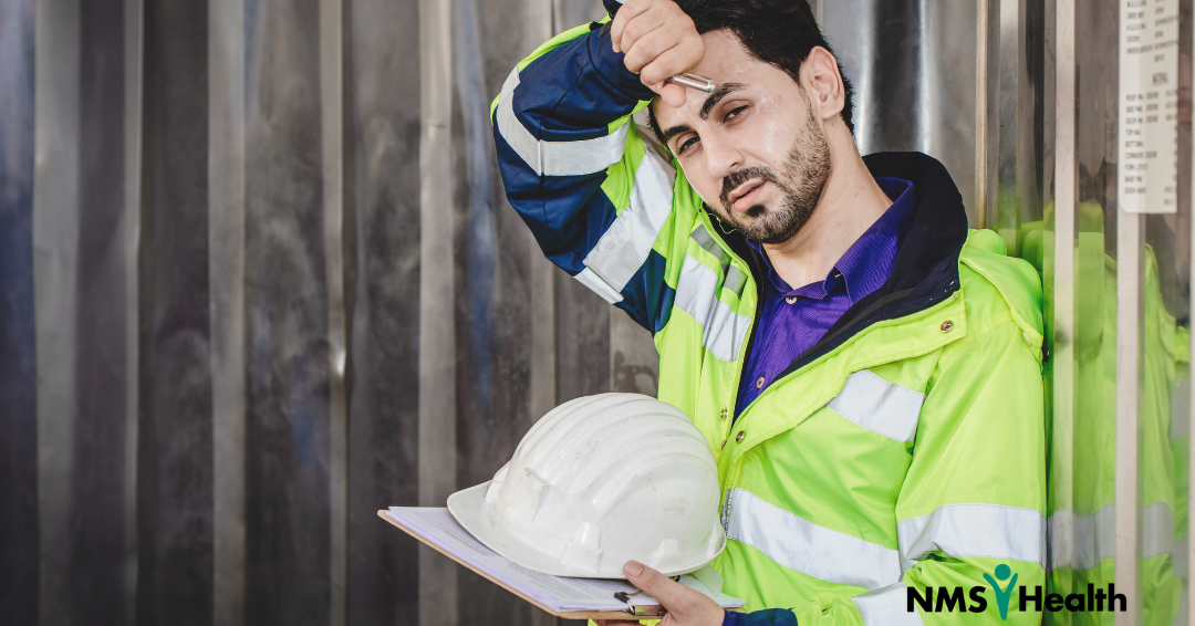 Construction worker dabs forehead
