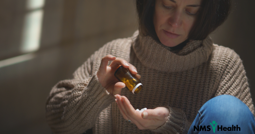 Woman emptying pill bottle into her hand