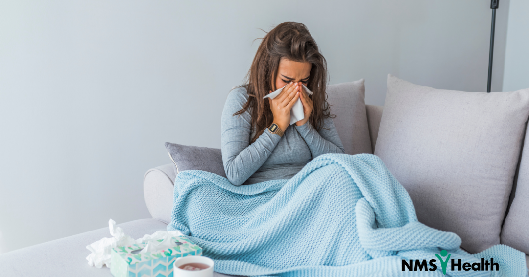 woman sneezing on a couch